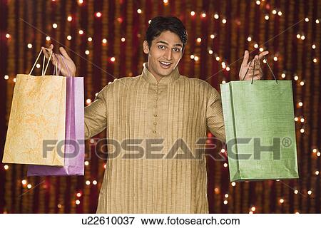 Man holding shopping bags View Large Photo Image Stock Photo - Man holding shopping bags. Fotosearch