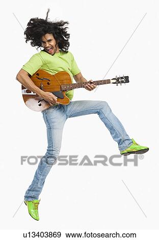 Man jumping in the air while playing a guitar View Large Photo Image Stock Photo - Man jumping in the air while playing a guitar. Fotosearch