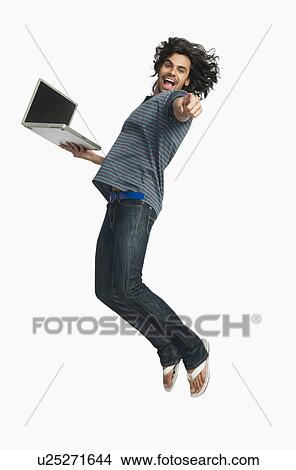 Man jumping while using a laptop View Large Photo Image Picture - Man jumping while using a laptop. Fotosearch