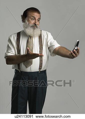 Stock Image - Man looking at a mobile phone. Fotosearch