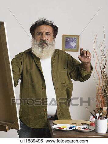 Man painting on a canvas View Large Photo Image Stock Photograph - Man painting on a canvas. Fotosearch