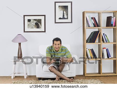 Man playing a video game View Large Photo Image Stock Photo - Man playing a video game. Fotosearch