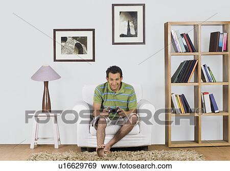 Man playing a video game View Large Photo Image Stock Photo - Man playing a video game. Fotosearch