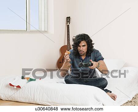 Man playing a video game View Large Photo Image Stock Photo - Man playing a video game. Fotosearch