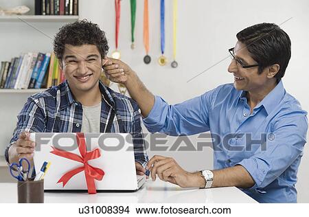 Man pulling ear of his son View Large Photo Image Picture - Man pulling ear of his son. Fotosearch