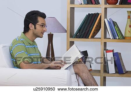Man reading a book in an armchair View Large Photo Image Stock Image - Man reading a book in an armchair. Fotosearch