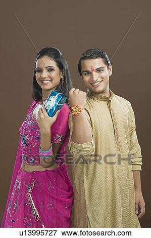 Man showing his rakhi with his sister showing her present View Large Photo Image Stock Photo - Man showing his rakhi with his sister showing her present. Fotosearch