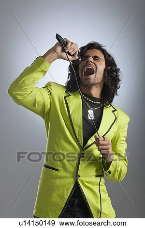 Man singing into a microphone View Large Photo Image Stock Photo - Man singing into a microphone. Fotosearch