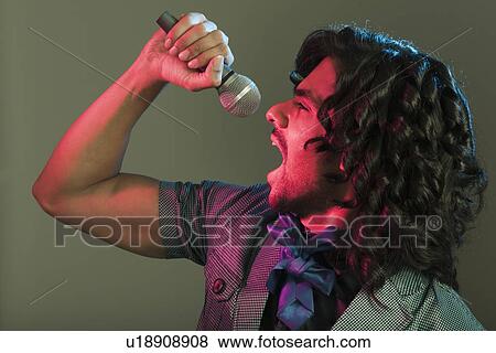 Man singing into a microphone View Large Photo Image Stock Photo - Man singing into a microphone. Fotosearch
