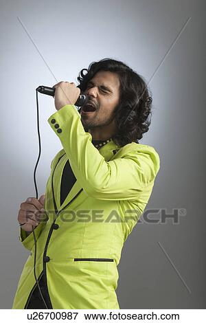 Man singing into a microphone View Large Photo Image Stock Photo - Man singing into a microphone. Fotosearch