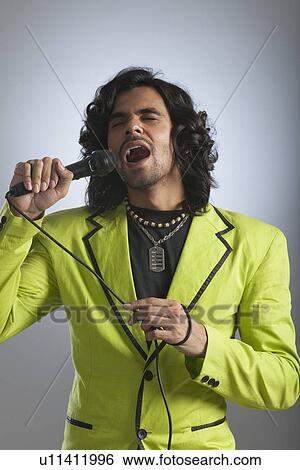 Man singing into a microphone View Large Photo Image Stock Photograph - Man singing into a microphone. Fotosearch