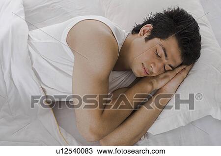 Stock Image - Man sleeping on the bed. Fotosearch