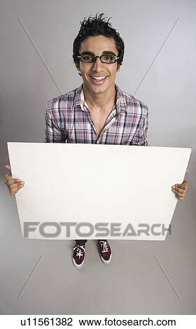 Stock Image - Man standing with a placard. Fotosearch