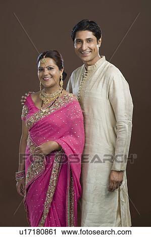 Man standing with his arm around his wife and smiling View Large Photo Image Stock Image - Man standing with his arm around his wife and smiling. Fotosearch