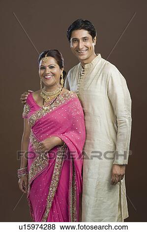 Man standing with his arm around his wife and smiling View Large Photo Image Stock Photo - Man standing with his arm around his wife and smiling. Fotosearch