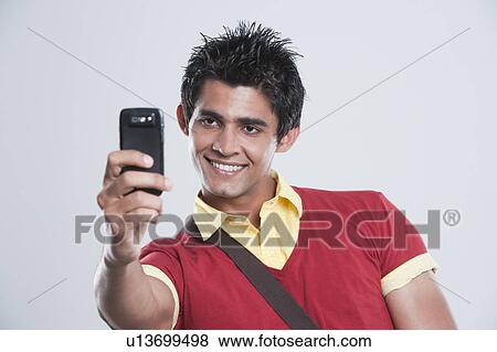 Man taking a picture with a mobile phone View Large Photo Image Stock Photo - Man taking a picture with a mobile phone. Fotosearch