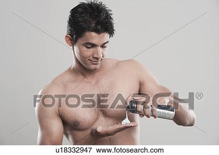 Stock Photo - Man taking out shaving foam from a can. Fotosearch