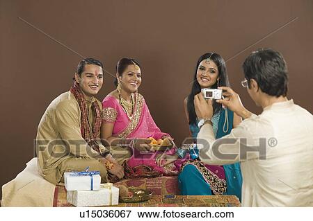 Stock Photo - Man taking picture of his family with a digital camera. Fotosearch