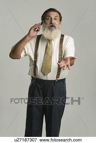 Stock Photo - Man talking on a mobile phone and gesturing. Fotosearch