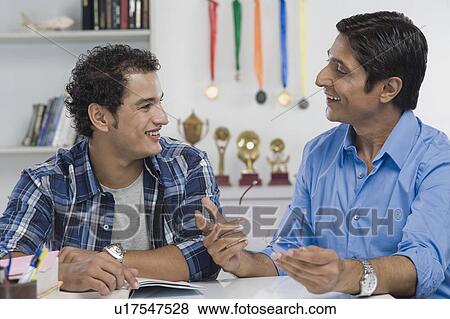Man talking to his son and smiling View Large Photo Image Stock Photo - Man talking to his son and smiling. Fotosearch