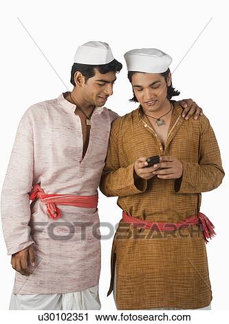 Stock Image - Man text messaging on a mobile phone with his friend. Fotosearch