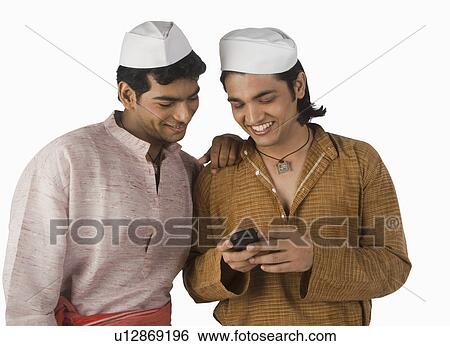 Stock Photograph - Man text messaging on a mobile phone with his friend. Fotosearch