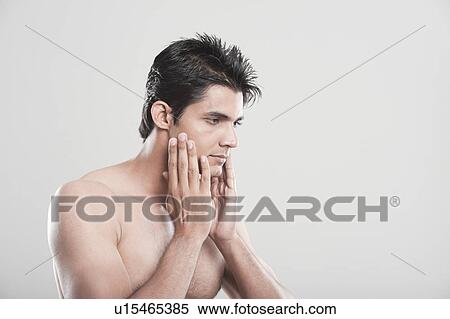 Stock Photography - Man touching his face after shaving. Fotosearch