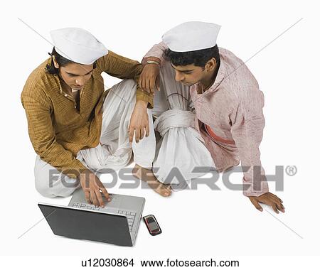 Picture - Man using a laptop with his friend. Fotosearch