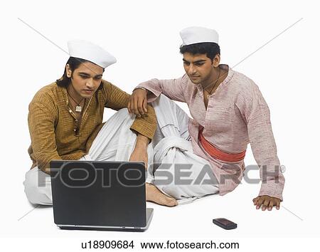Picture - Man using a laptop with his friend. Fotosearch