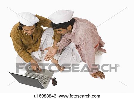 Man using a laptop with his friend View Large Photo Image Stock Image - Man using a laptop with his friend. Fotosearch