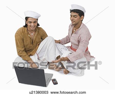 Man using a laptop with his friend View Large Photo Image Stock Image - Man using a laptop with his friend. Fotosearch