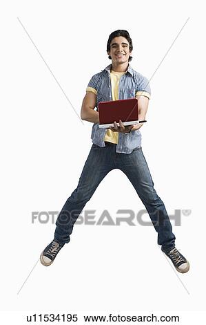 Man working on a laptop and jumping View Large Photo Image Stock Photography - Man working on a laptop and jumping. Fotosearch