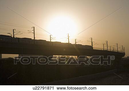 Metro train on elevated tracks at sunset, Delhi, India View Large Photo Image Stock Image - Metro train on elevated tracks at sunset, Delhi, India. Fotosearch