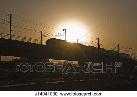 Metro train on elevated tracks at sunset, New Delhi, India View Large Photo Image Stock Photo - Metro train on elevated tracks at sunset, New Delhi, India. Fotosearch