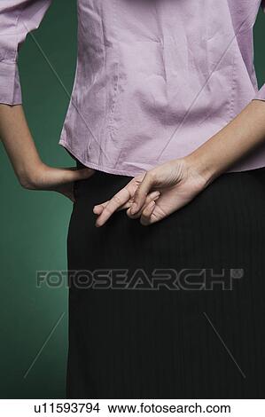 Mid section view of a businesswoman with fingers crossed behind her back View Large Photo Image Picture - Mid section view of a businesswoman with fingers crossed behind her back. Fotosearch
