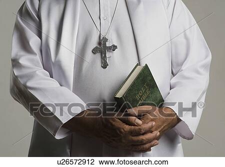 Mid section view of a priest praying View Large Photo Image Stock Image - Mid section view of a priest praying. Fotosearch