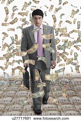 Stock Image - Money shower on a businessman. Fotosearch