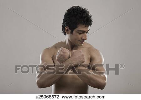 Stock Image - Muscular man flexing his biceps. Fotosearch