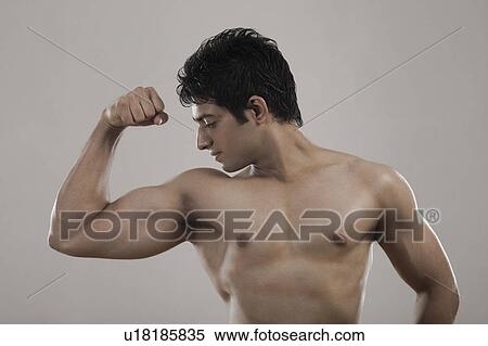 Muscular man flexing his biceps View Large Photo Image Stock Photography - Muscular man flexing his biceps. Fotosearch