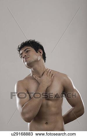 Stock Image - Muscular man suffering from neckache. Fotosearch