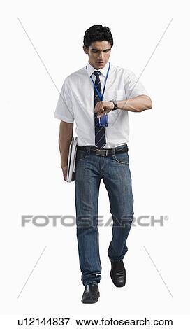 Stock Photo - Office worker looking at wristwatch. Fotosearch