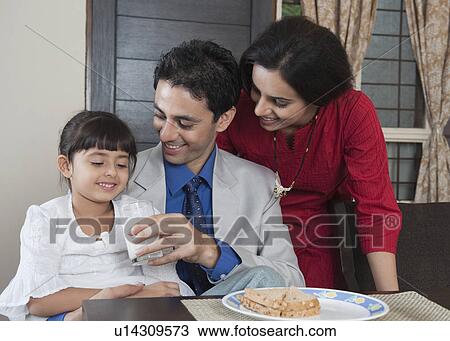 Parents feeding milk to their daughter View Large Photo Image Stock Image - Parents feeding milk to their daughter. Fotosearch