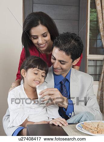 Parents feeding milk to their daughter View Large Photo Image Stock Photo - Parents feeding milk to their daughter. Fotosearch