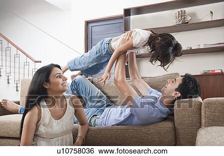 Stock Photograph - Parents playing with their daughter. Fotosearch