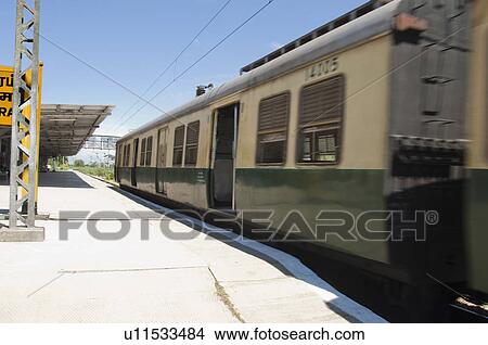 Picture - Passenger train at a railroad station, Kanchipuram, Tamil Nadu, India. Fotosearch