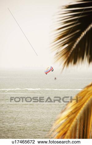 Stock Image - Person paragliding over the sea, Goa, India. Fotosearch