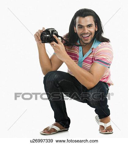 Stock Photo - Photographer taking a picture with a digital camera. Fotosearch