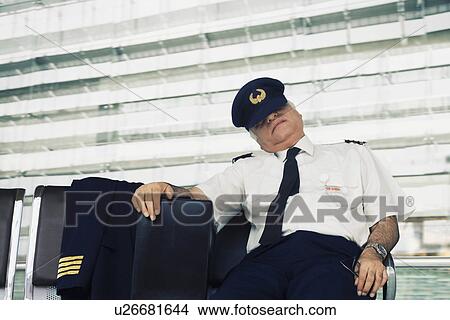 Pilot resting on a bench at an airport View Large Photo Image Picture - Pilot resting on a bench at an airport. Fotosearch