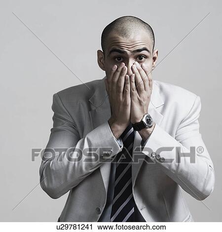 Portrait of a businessman covering his mouth with his hands View Large Photo Image Stock Image - Portrait of a businessman covering his mouth with his hands. Fotosearch