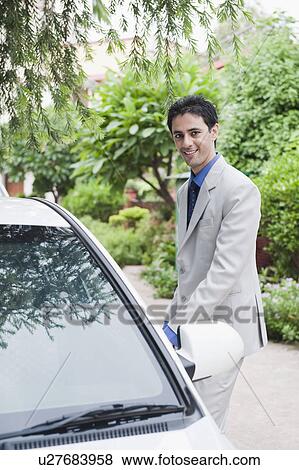 Portrait of a businessman getting into a car View Large Photo Image Stock Photo - Portrait of a businessman getting into a car. Fotosearch